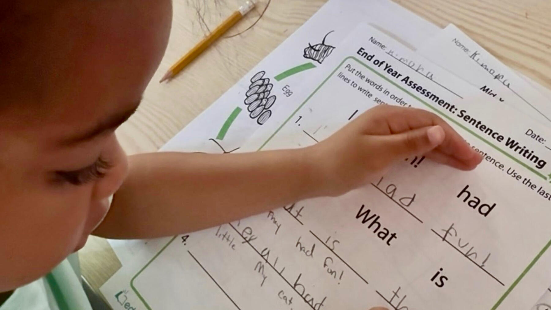Young child practicing reading and sentence writing during a structured learning activity at Advanced Childcare Services LLC